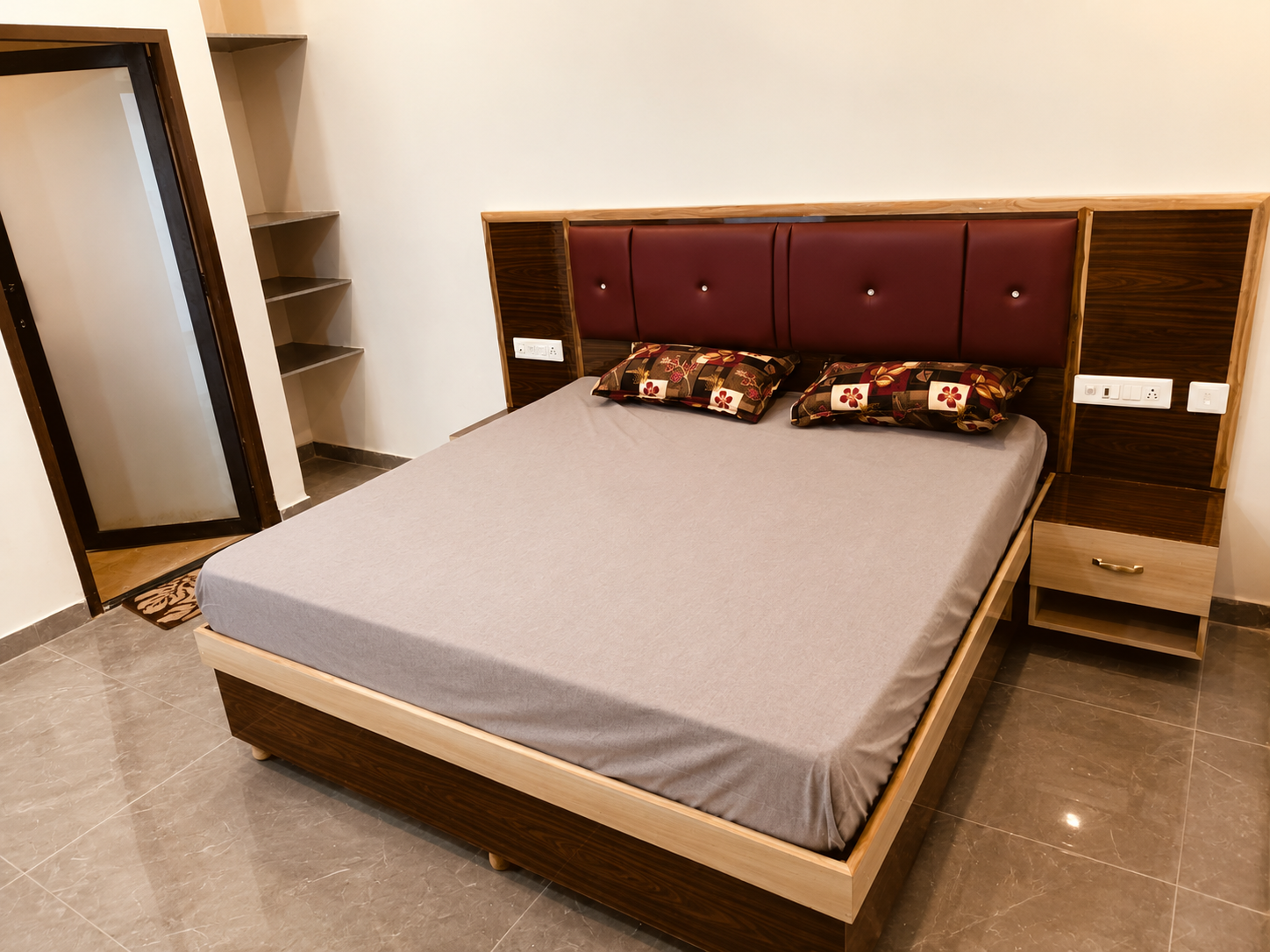 AC bedroom at Mandiya Villa with a king bed, wooden frame and a cushioned maroon headboard.